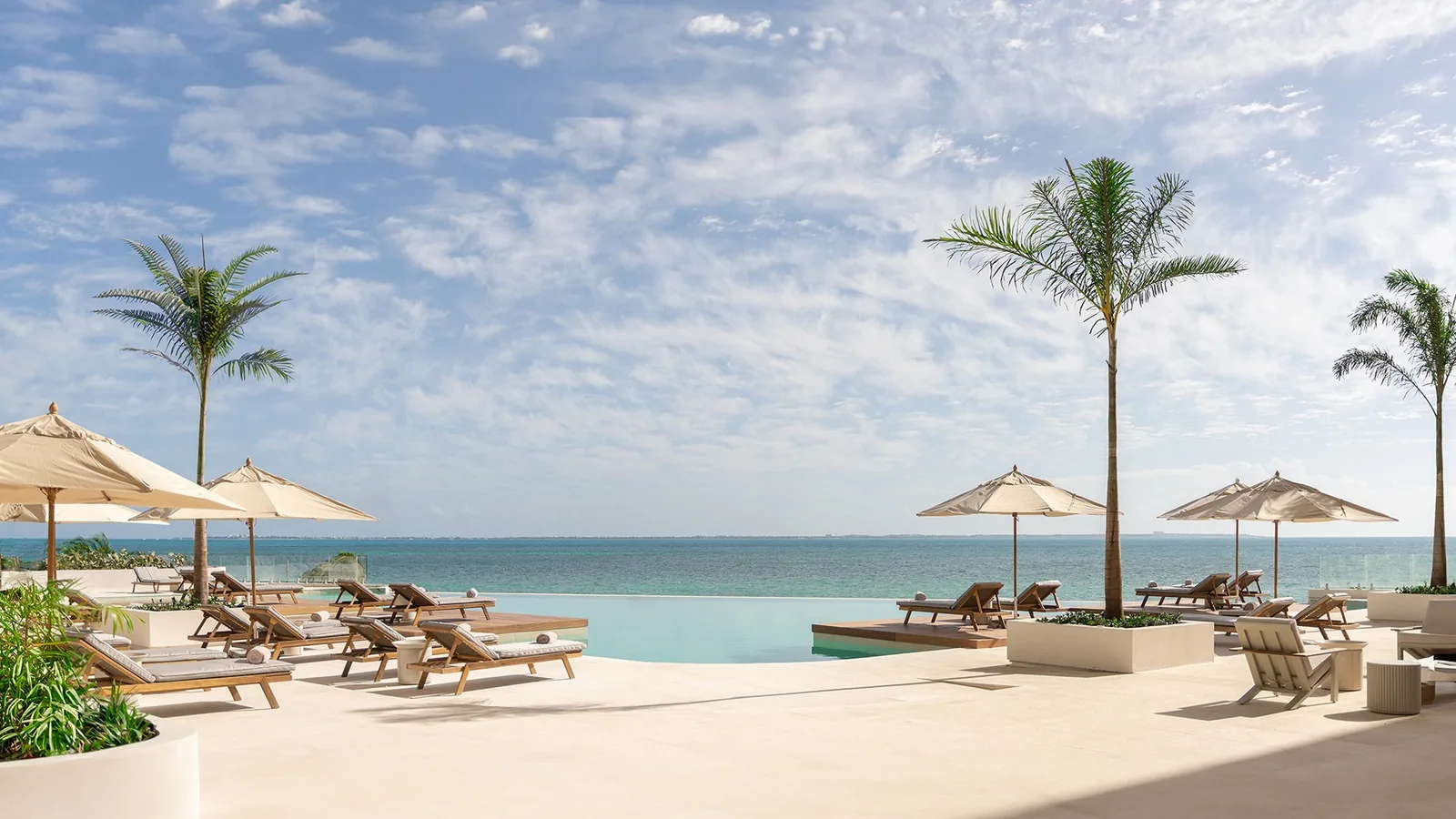 SHA Wellness Clinic, SHA Mexico: infinity pool with loungers, parasols and palms facing the Caribbean Sea