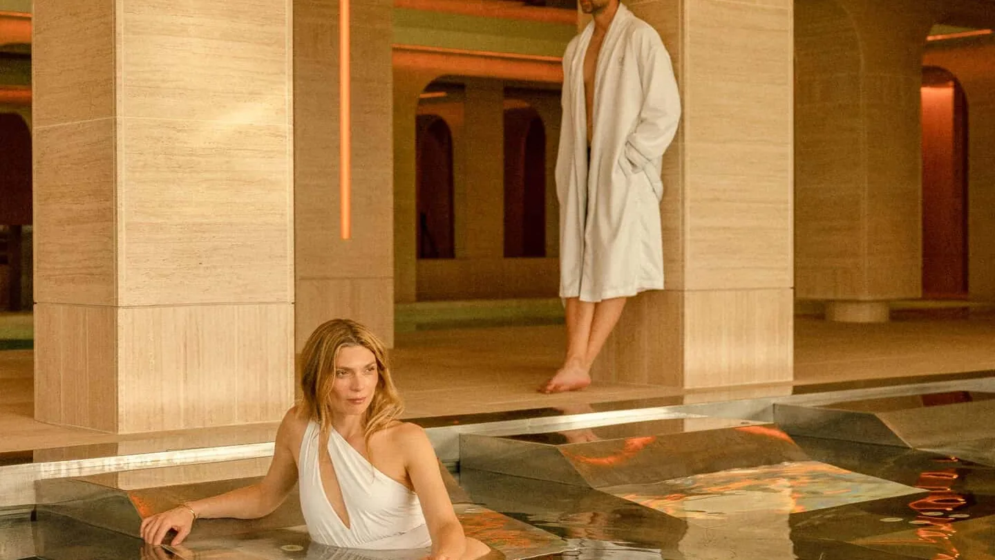 Spa pool under stone arches at SHA Wellness Clinic in Spain, one guest in the water and another in a bathrobe