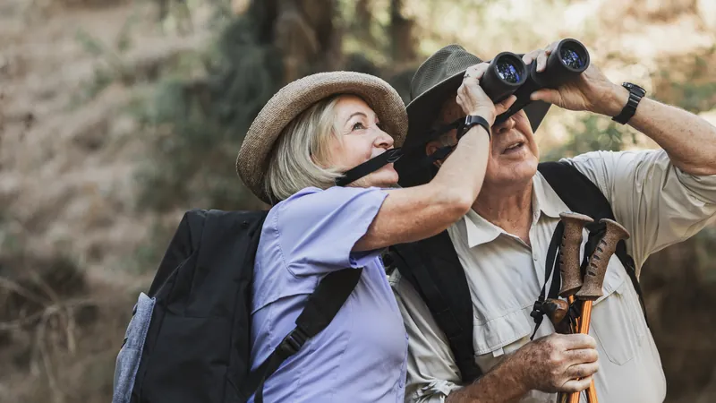 Retired couple walking side by side along a path through a forest