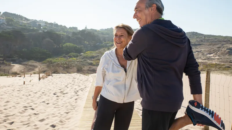 Older couple stretching together outdoors in sportswear