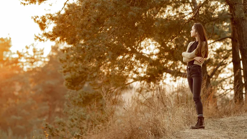 Woman outdoors with her eyes closed and her face turned towards the sunlight