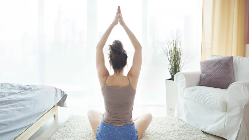 Woman sitting calmly with closed eyes in a bright room